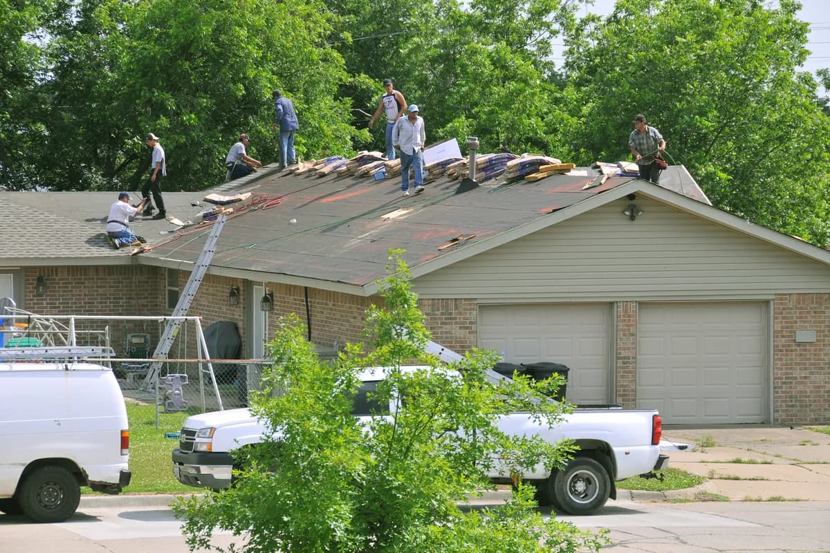 Workers carrying out repairs on a residential roof