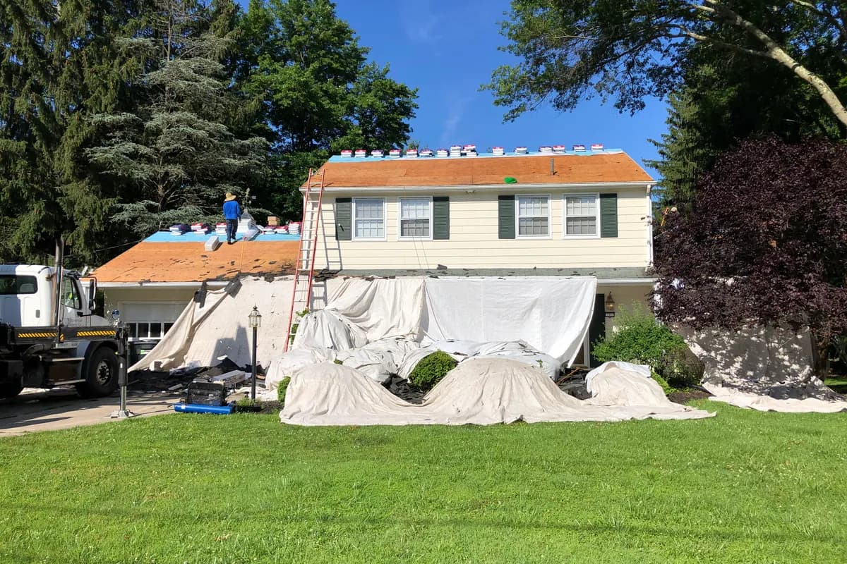 A house roof being replaced, with workers on the roof surface